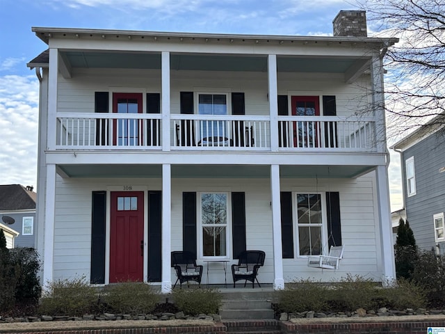 view of front of home featuring covered porch and a chimney