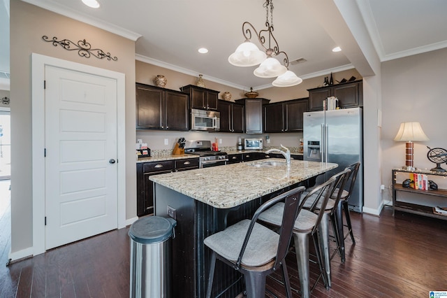 kitchen featuring visible vents, appliances with stainless steel finishes, dark wood-type flooring, dark brown cabinetry, and light stone countertops