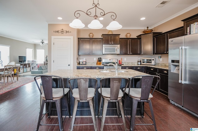 kitchen with crown molding, visible vents, white microwave, a sink, and high end refrigerator