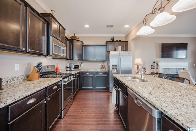 kitchen featuring light stone countertops, visible vents, stainless steel appliances, and crown molding