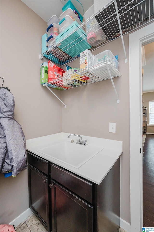 washroom featuring baseboards and a sink