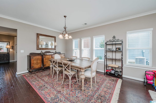 dining area with dark wood-style floors, crown molding, a chandelier, and baseboards