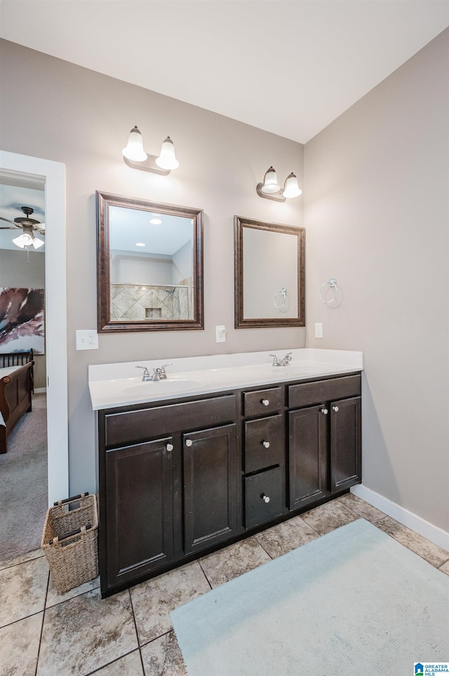 ensuite bathroom with a ceiling fan, a sink, baseboards, and double vanity