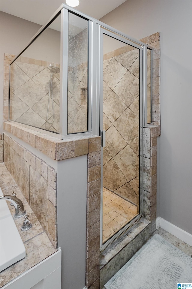 full bathroom with a stall shower and baseboards