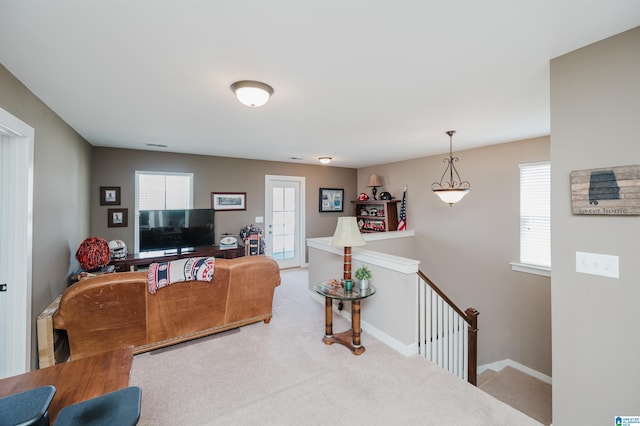 carpeted living room featuring baseboards