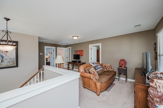 living area with attic access, light carpet, visible vents, and baseboards