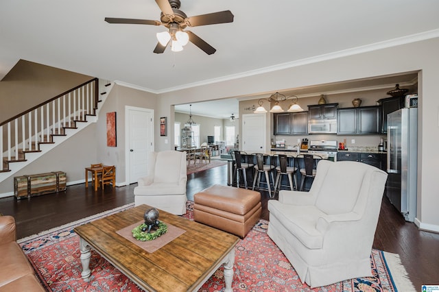 living area with ceiling fan, dark wood-type flooring, baseboards, stairs, and crown molding