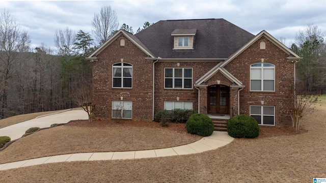 view of front of home featuring brick siding, roof with shingles, and french doors