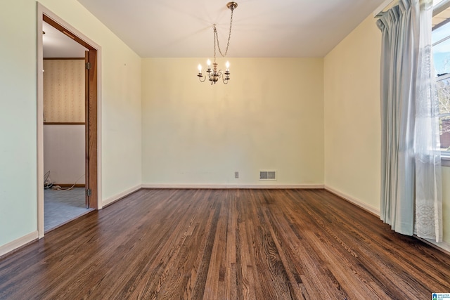 unfurnished room featuring dark wood-style floors, baseboards, visible vents, and a chandelier