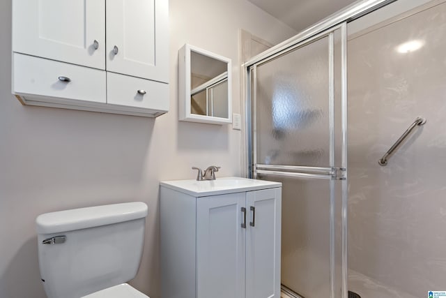 bathroom featuring a shower stall, toilet, and vanity