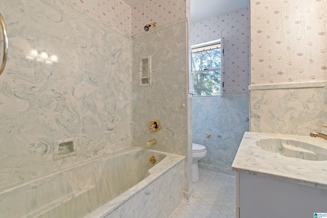 bathroom featuring tile patterned flooring, toilet, a combined bath / shower with marble appearance, vanity, and wallpapered walls