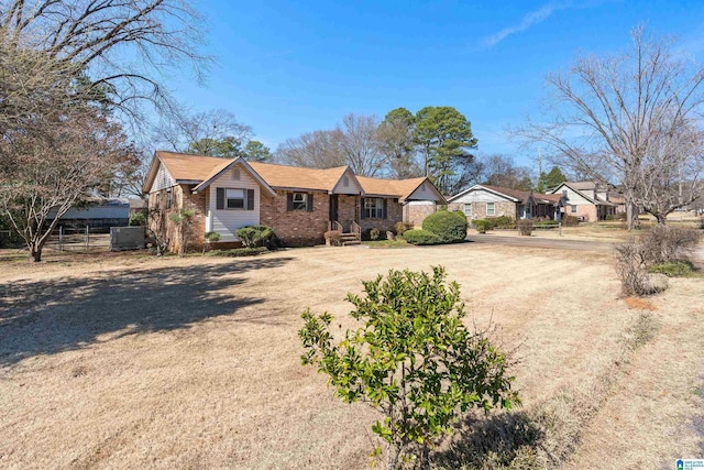 ranch-style house featuring a residential view, brick siding, and fence