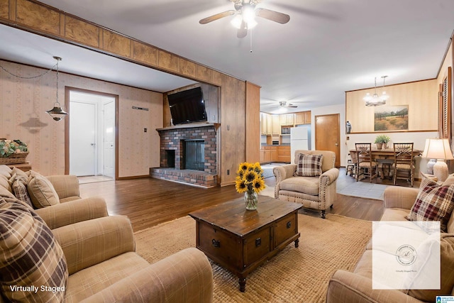 141 Newport Dr, Hueytown, AL 35023 - living area with a ceiling fan, wood finished floors, a fireplace, and a chandelier