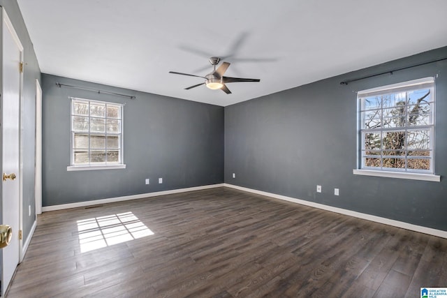 unfurnished room with dark wood-style floors, a ceiling fan, and baseboards