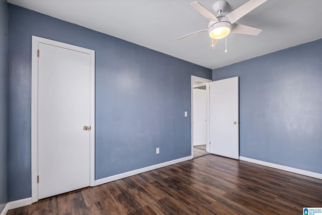 unfurnished bedroom with ceiling fan, dark wood finished floors, and baseboards