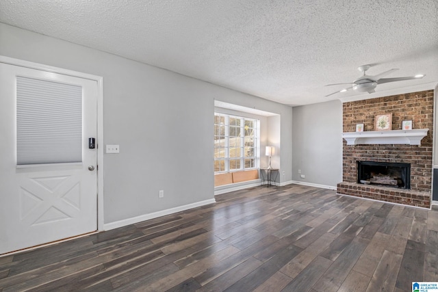 unfurnished living room with a ceiling fan, dark wood-style flooring, a fireplace, and a textured ceiling