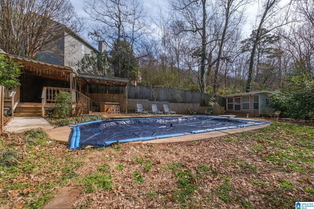 view of pool featuring an outbuilding, a deck, fence, and a fenced in pool