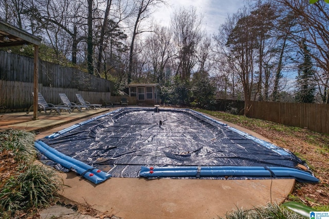 view of swimming pool featuring a fenced in pool, an outbuilding, and a fenced backyard