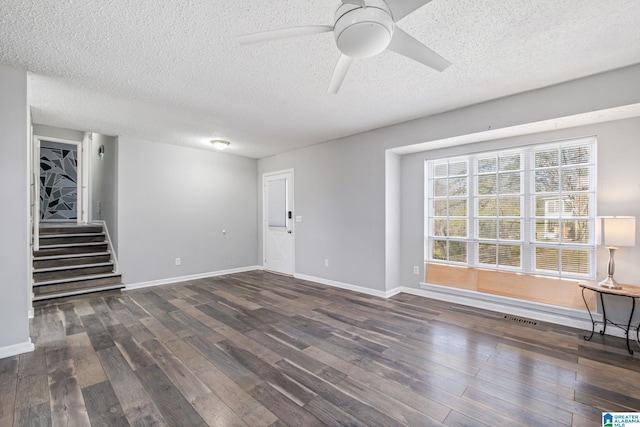 unfurnished living room with dark wood-style floors, stairs, and baseboards