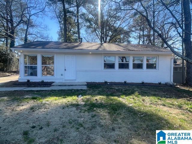 single story home with brick siding and a front lawn