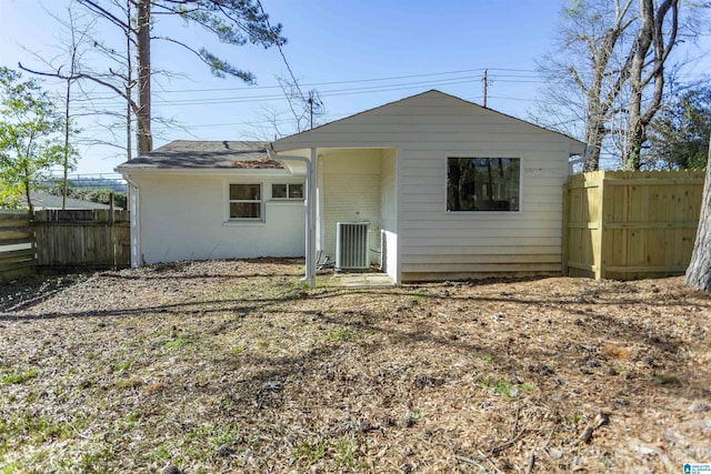 back of property with cooling unit, brick siding, and fence