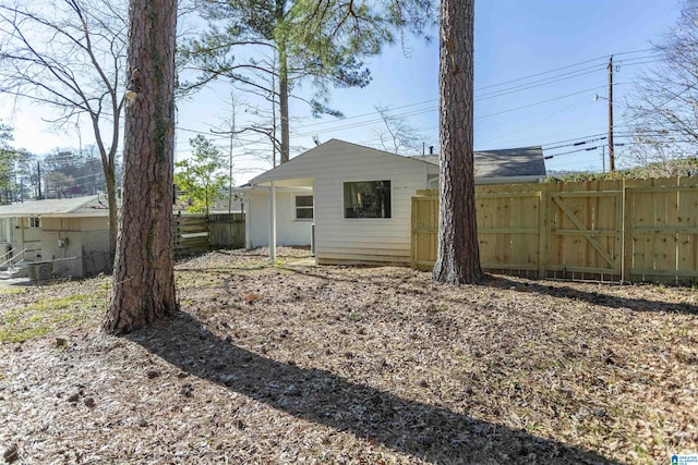 back of property with a gate and fence