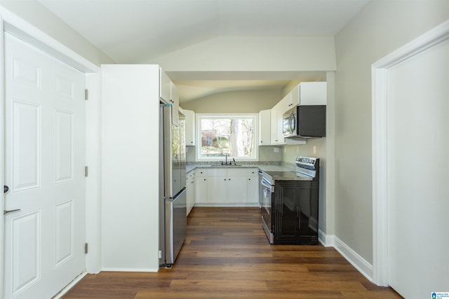 kitchen featuring dark wood-style flooring, stainless steel appliances, lofted ceiling, white cabinetry, and a sink