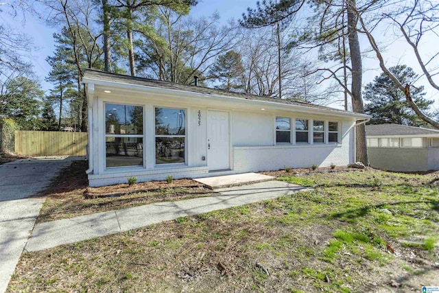 view of front of house with brick siding and fence