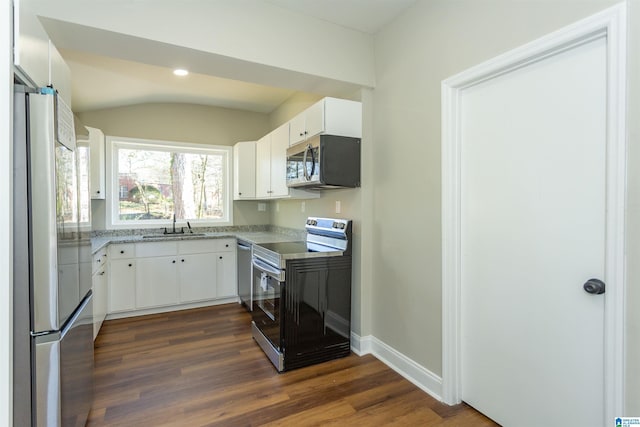 kitchen featuring stainless steel appliances, white cabinets, dark wood finished floors, and a sink