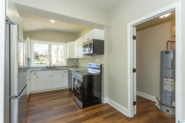 kitchen featuring appliances with stainless steel finishes, white cabinets, electric water heater, and a sink