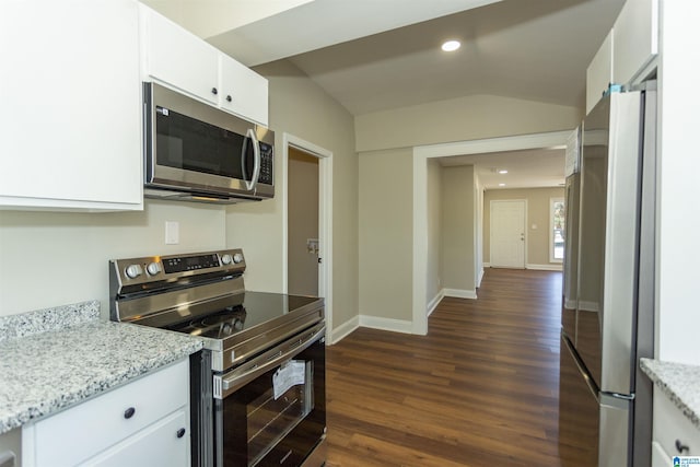 kitchen featuring light stone counters, stainless steel appliances, white cabinetry, vaulted ceiling, and dark wood-style floors