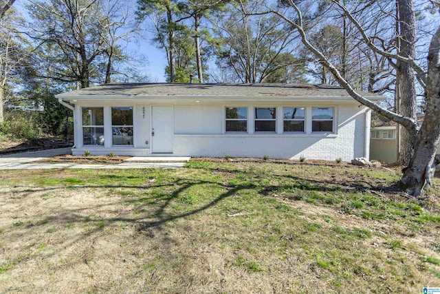 single story home featuring brick siding and a front yard