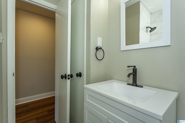 bathroom featuring baseboards, wood finished floors, and vanity