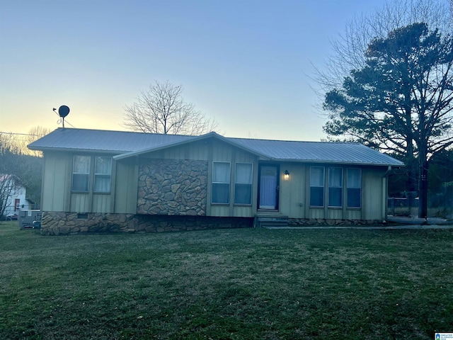 view of front of property featuring crawl space, metal roof, board and batten siding, and a yard