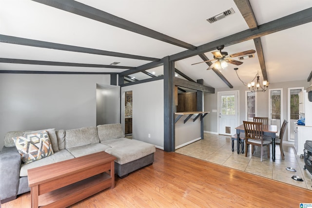 living room featuring vaulted ceiling with beams, ceiling fan with notable chandelier, visible vents, baseboards, and light wood-style floors