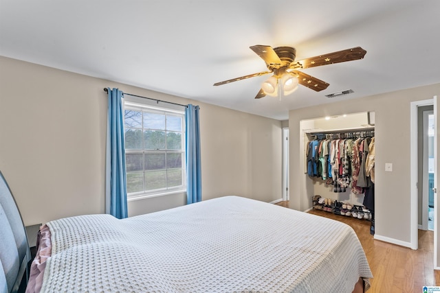 bedroom with ceiling fan, visible vents, baseboards, a closet, and light wood finished floors