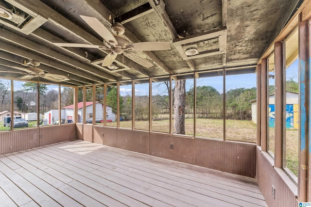 unfurnished sunroom featuring a ceiling fan