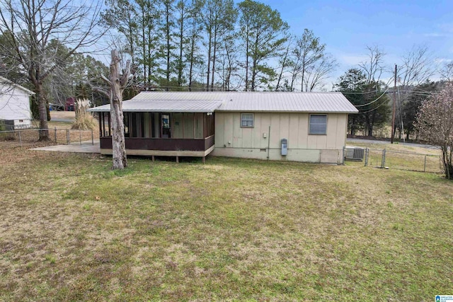 back of house with metal roof, fence, crawl space, a lawn, and a gate