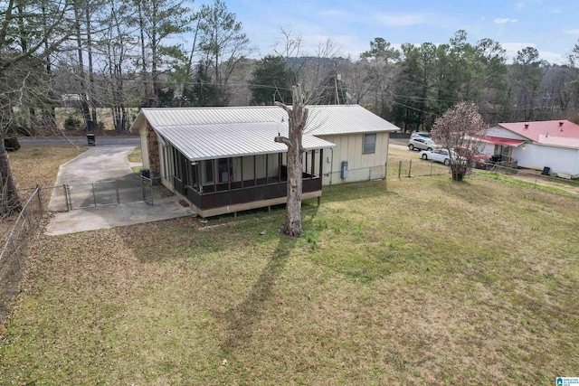 exterior space with metal roof, a front yard, and fence