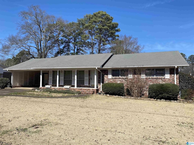 ranch-style house featuring covered porch and brick siding