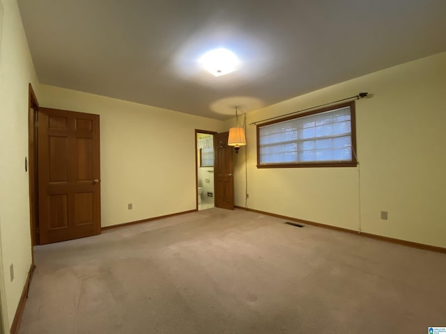 unfurnished room with baseboards, visible vents, and light colored carpet