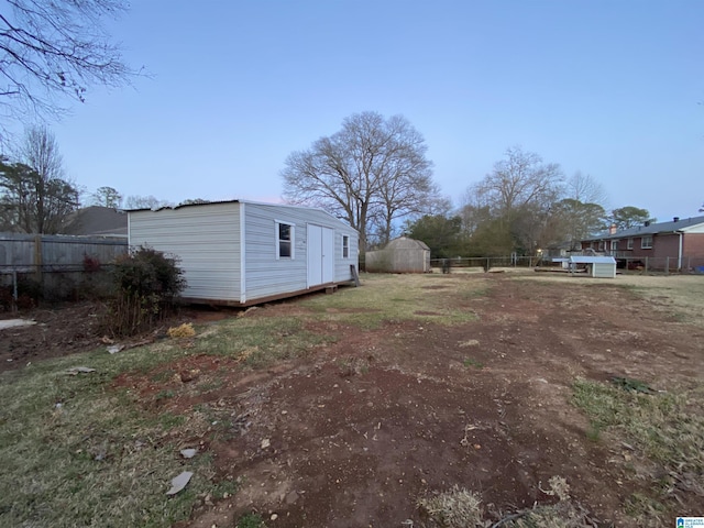 view of yard with an outbuilding, a shed, and fence