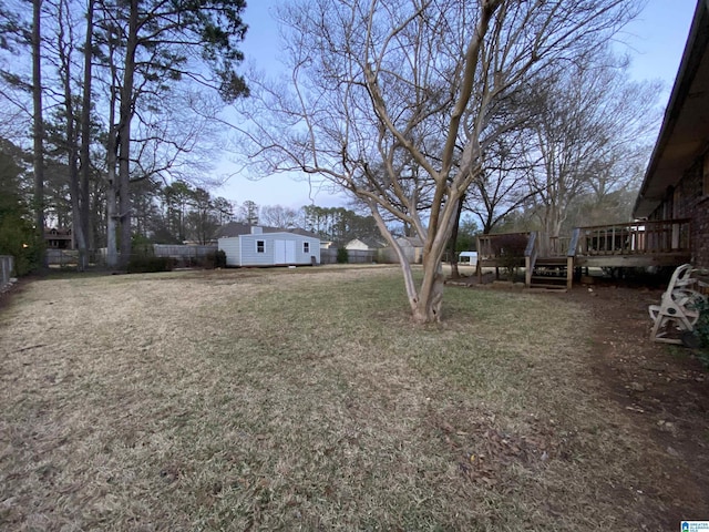 view of yard with an outdoor structure, a deck, and fence