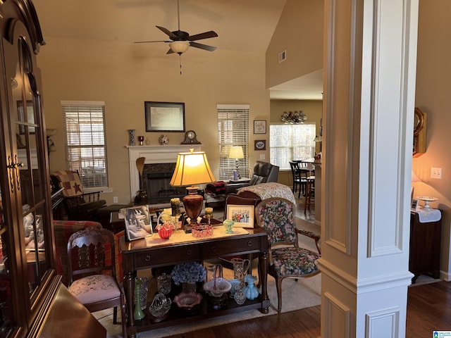 living room featuring ceiling fan, high vaulted ceiling, wood finished floors, visible vents, and a high end fireplace