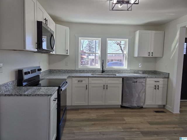 kitchen featuring electric range, dark wood-style flooring, a sink, white cabinets, and stainless steel dishwasher