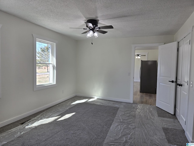 empty room featuring a ceiling fan, baseboards, and a textured ceiling