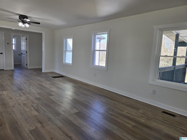 unfurnished living room featuring dark wood-style floors, baseboards, and visible vents