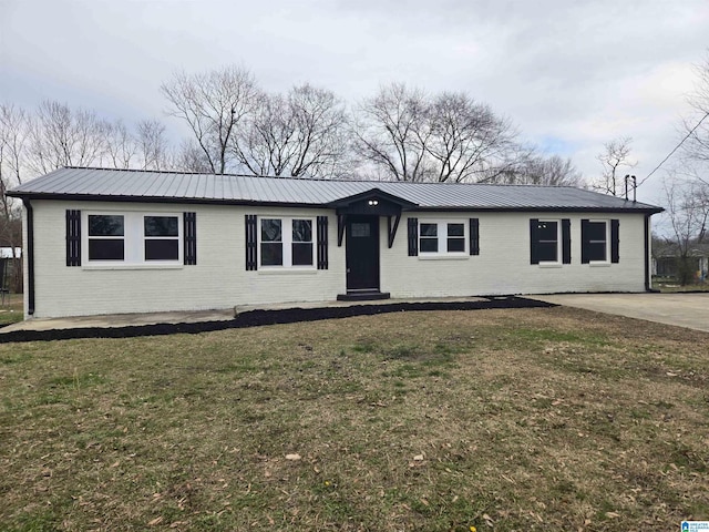 view of front of house featuring a front yard, metal roof, and brick siding