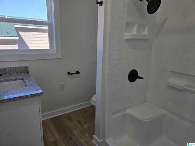 full bath featuring baseboards, toilet, wood finished floors, walk in shower, and vanity