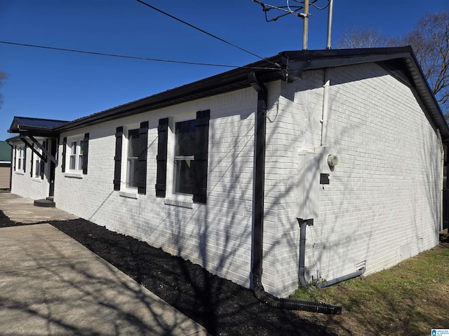 view of home's exterior with brick siding and a patio area